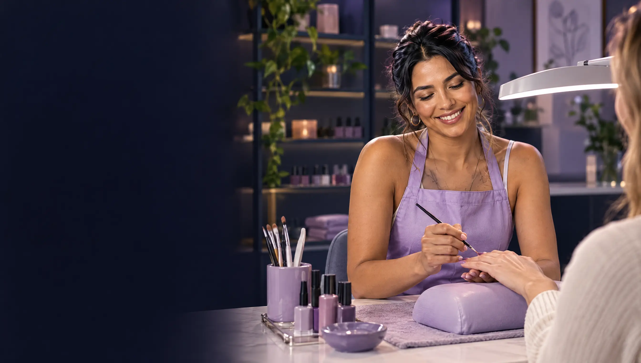 Eine Nageldesignerin arbeitet an einer Maniküre in ihrem Studio.
